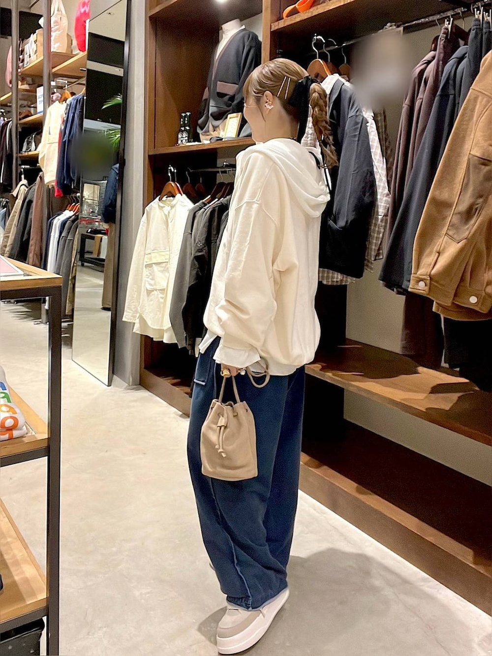 ベージュ系のショルダーバッグ、ホワイト系のパーカー、ホワイト系のTシャツ/カットソーを着用したレディースの冬コーディネートの4枚目の写真