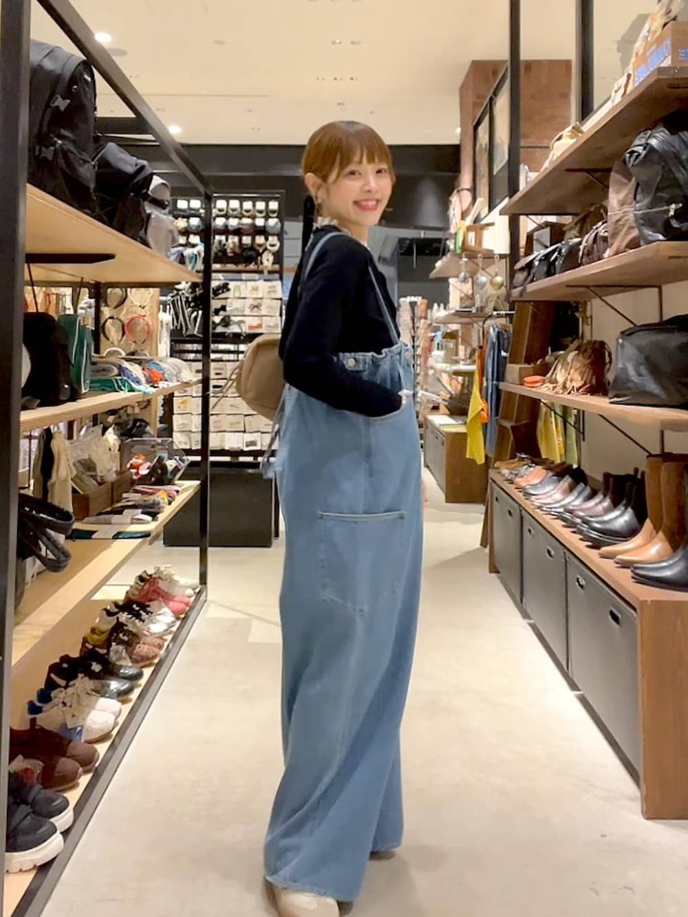 ブラック系のカーディガン/ボレロ、ベージュ系のボストンバッグを着用したレディースの秋コーディネートの5枚目の写真