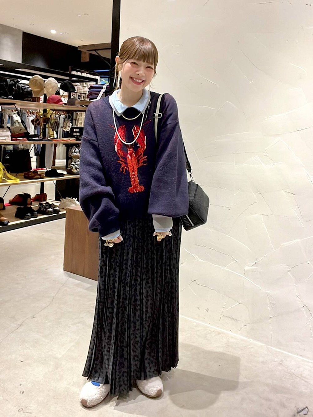 グレー系のスカート、ブラック系のショルダーバッグ、ベージュ系のスニーカーを着用したレディースの冬コーディネートの5枚目の写真