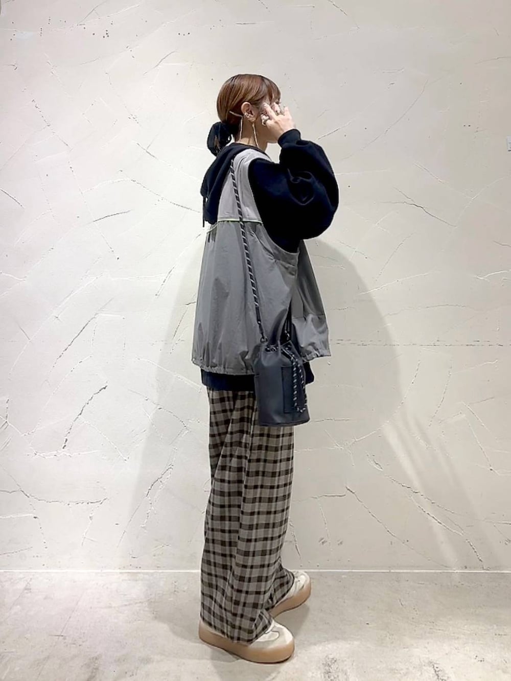 ブラック系のショルダーバッグ、ブラウン系のその他パンツ、イエロー系のネックレスを着用したレディースの秋コーディネートの4枚目の写真