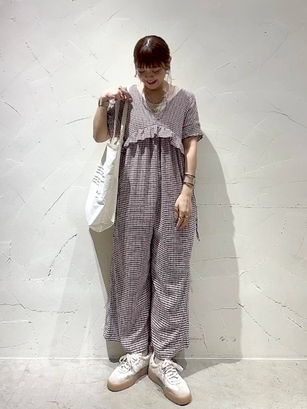 ベージュ系のトートバッグ、イエロー系のアナログ腕時計、ゴールド系のネックレスを着用したレディースの春コーディネートの9枚目の写真