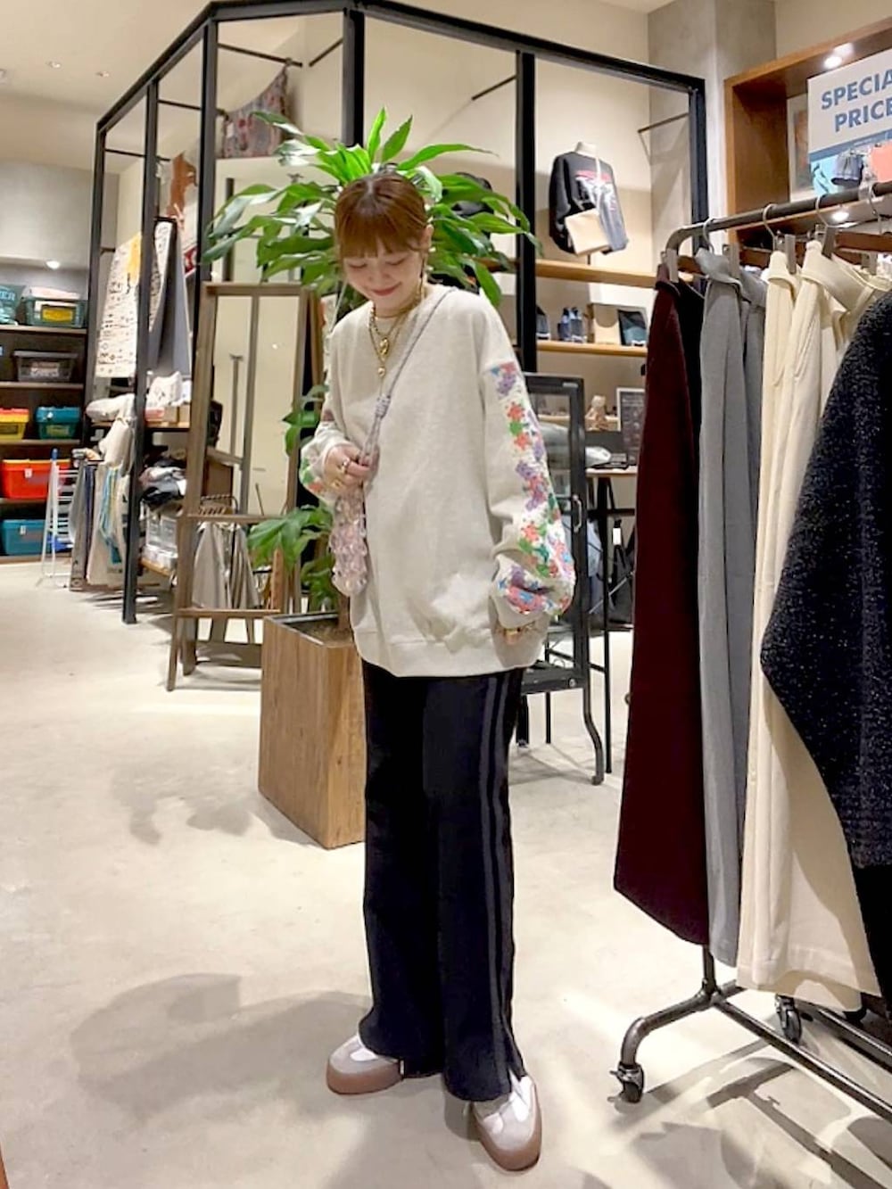 ピンク系のショルダーバッグ、ブラック系のその他パンツ、ベージュ系のスウェットを着用したレディースの春コーディネートの2枚目の写真