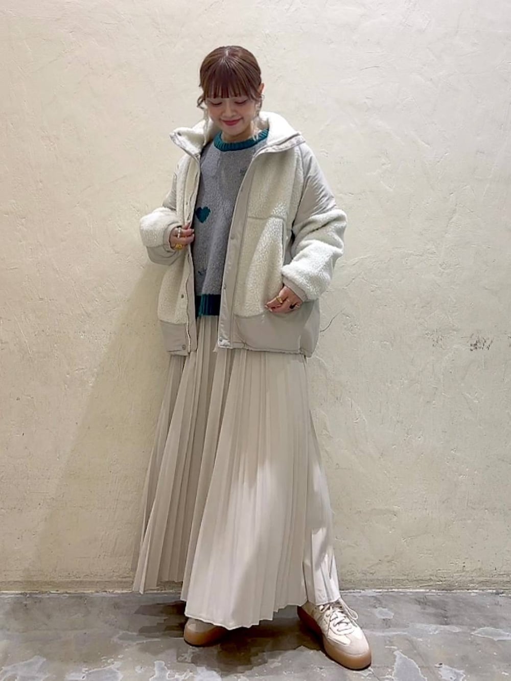 ベージュ系のスカート、ベージュ系のブルゾン、グレー系のニット/セーターを着用したレディースの秋コーディネートの7枚目の写真
