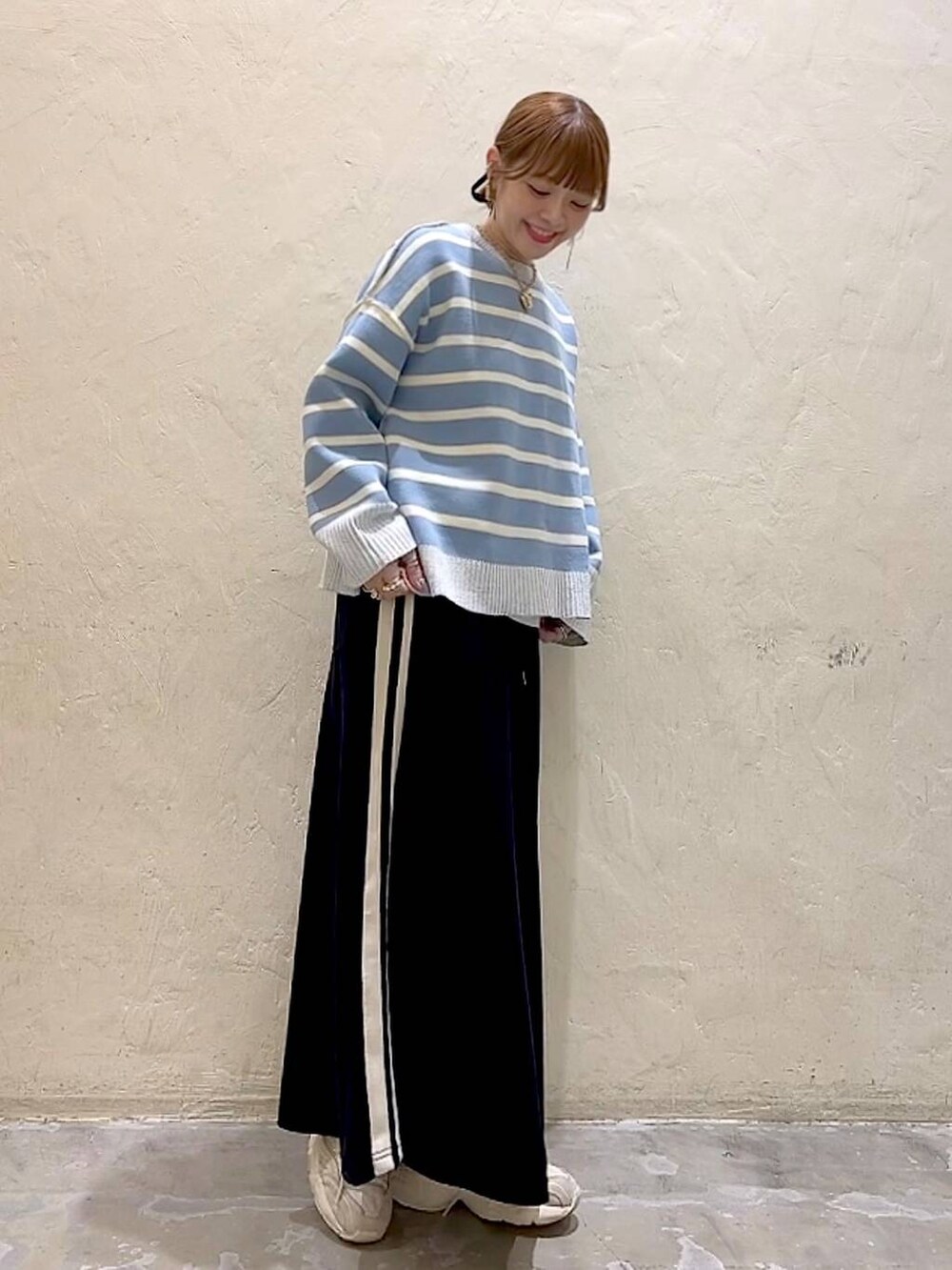 ホワイト系のTシャツ/カットソー、ブラック系のスカート、ベージュ系のニット/セーターを着用したレディースの冬コーディネートの8枚目の写真