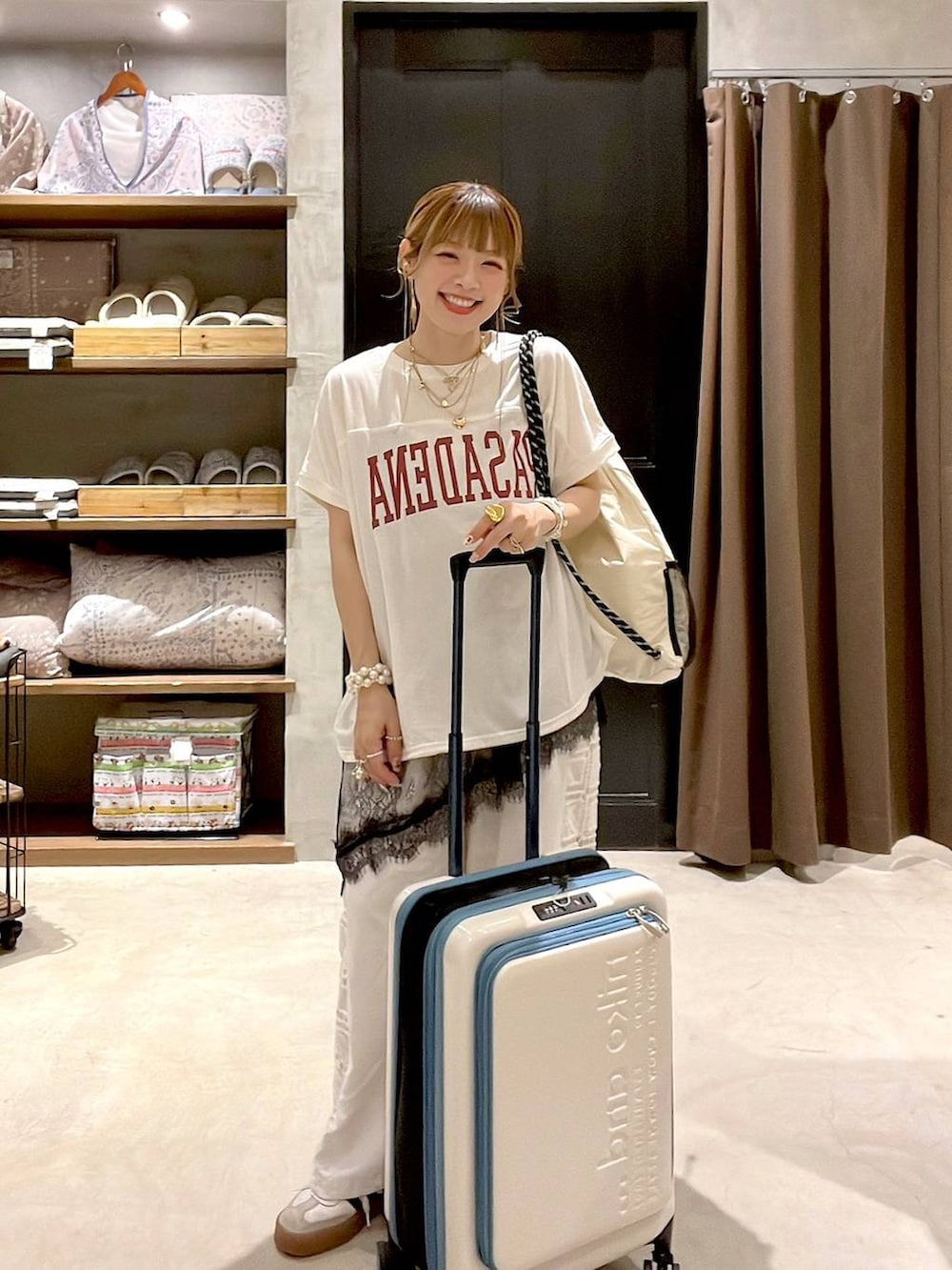 ホワイト系のその他パンツ、ベージュ系のスーツケース/キャリーバッグ、ホワイト系のバックパック/リュックを着用したレディースの夏コーディネートの5枚目の写真