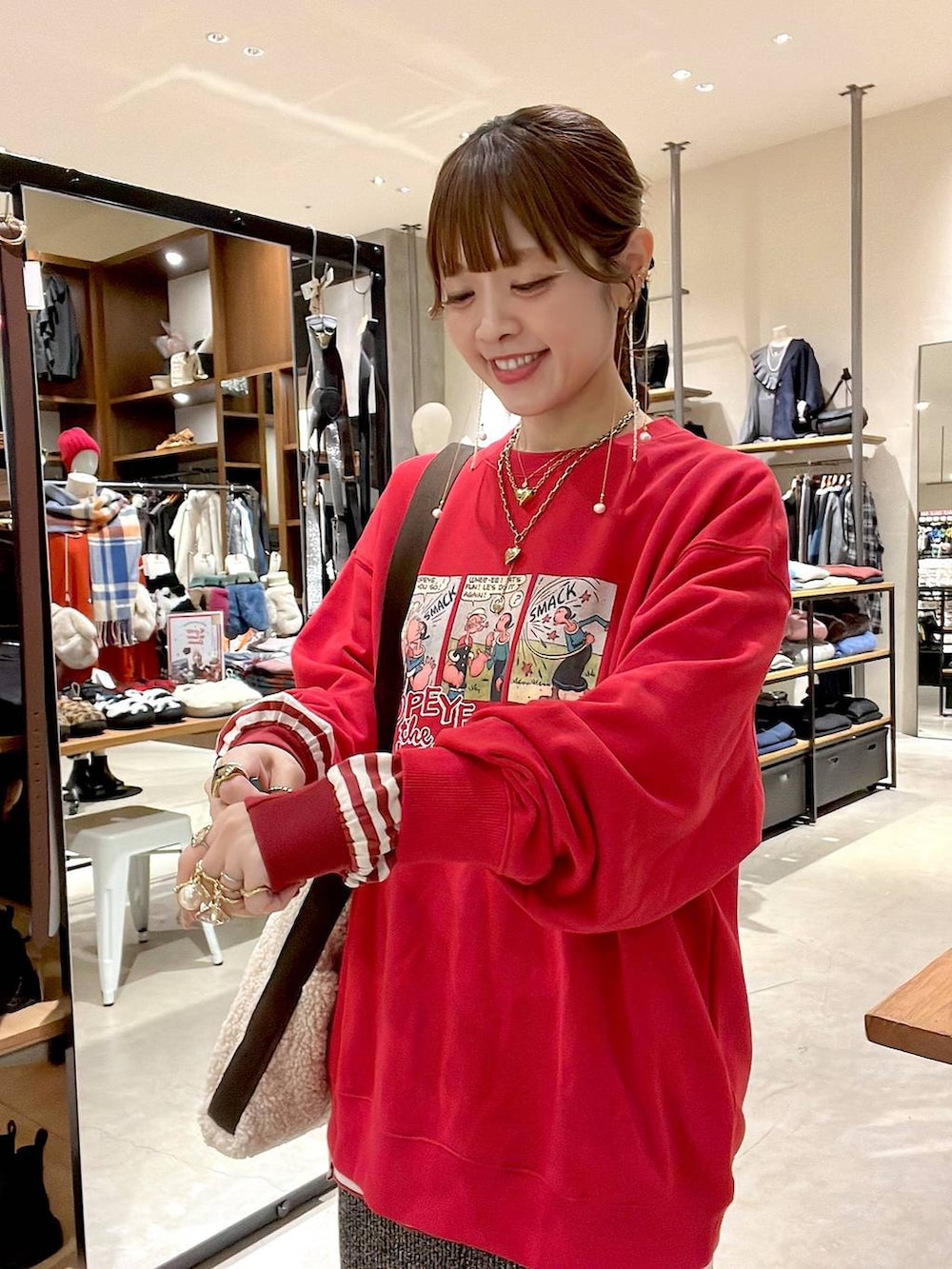 レッド系のTシャツ/カットソー、ホワイト系のスカート、ベージュ系のトートバッグを着用したレディースの冬コーディネートの3枚目の写真