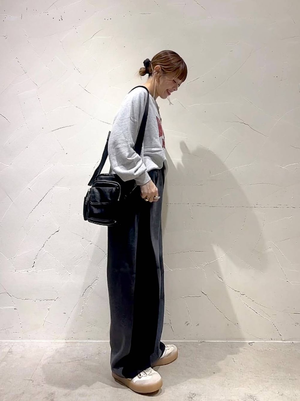 ベージュ系のスウェット、ブラック系のショルダーバッグ、イエロー系のネックレスを着用したレディースの秋コーディネートの5枚目の写真