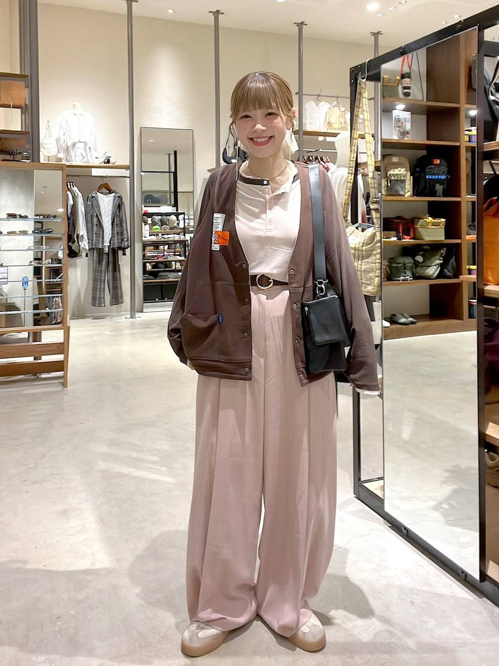 ピンク系のTシャツ/カットソー、ピンク系のスラックス、ブラウン系のベルトを着用したレディースの秋コーディネートの5枚目の写真