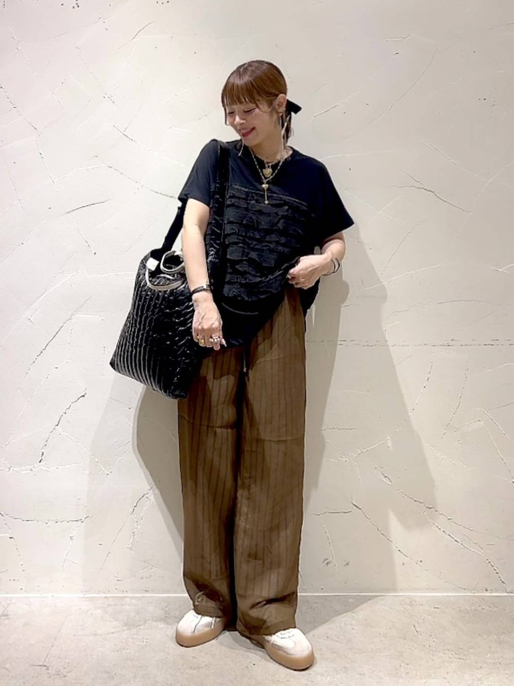 ブラック系のTシャツ/カットソー、ブラウン系のその他パンツ、ブラック系のトートバッグを着用したレディースの夏コーディネートの2枚目の写真