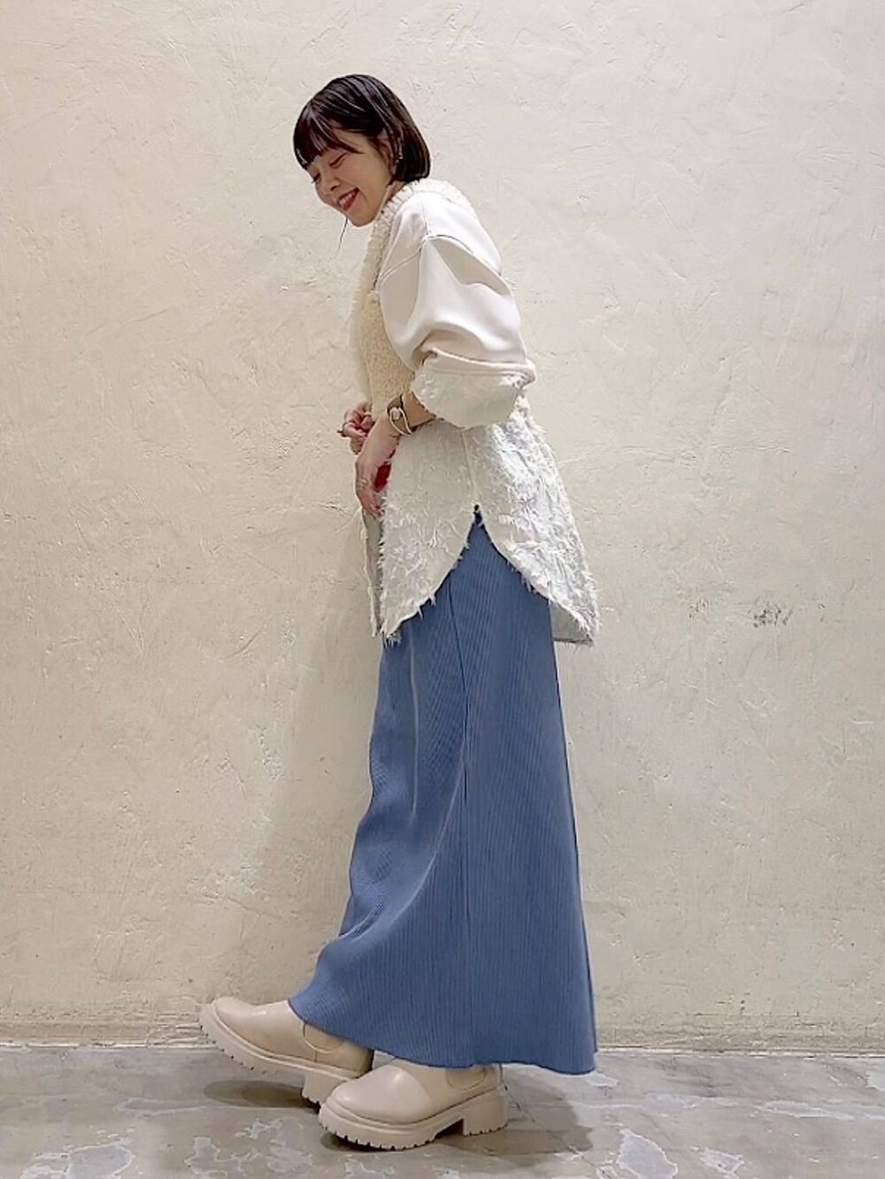 ベージュ系のシャツ/ブラウス、ベージュ系のベスト、ベージュ系のブーツを着用したレディースの冬コーディネートの5枚目の写真