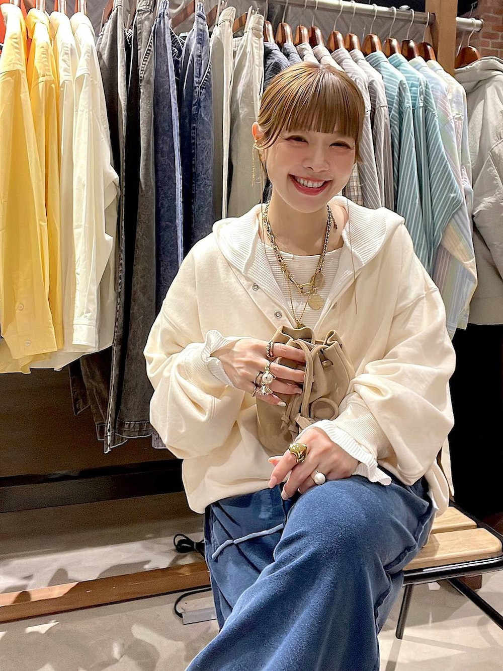 ベージュ系のショルダーバッグ、ホワイト系のパーカー、ホワイト系のTシャツ/カットソーを着用したレディースの冬コーディネートの5枚目の写真