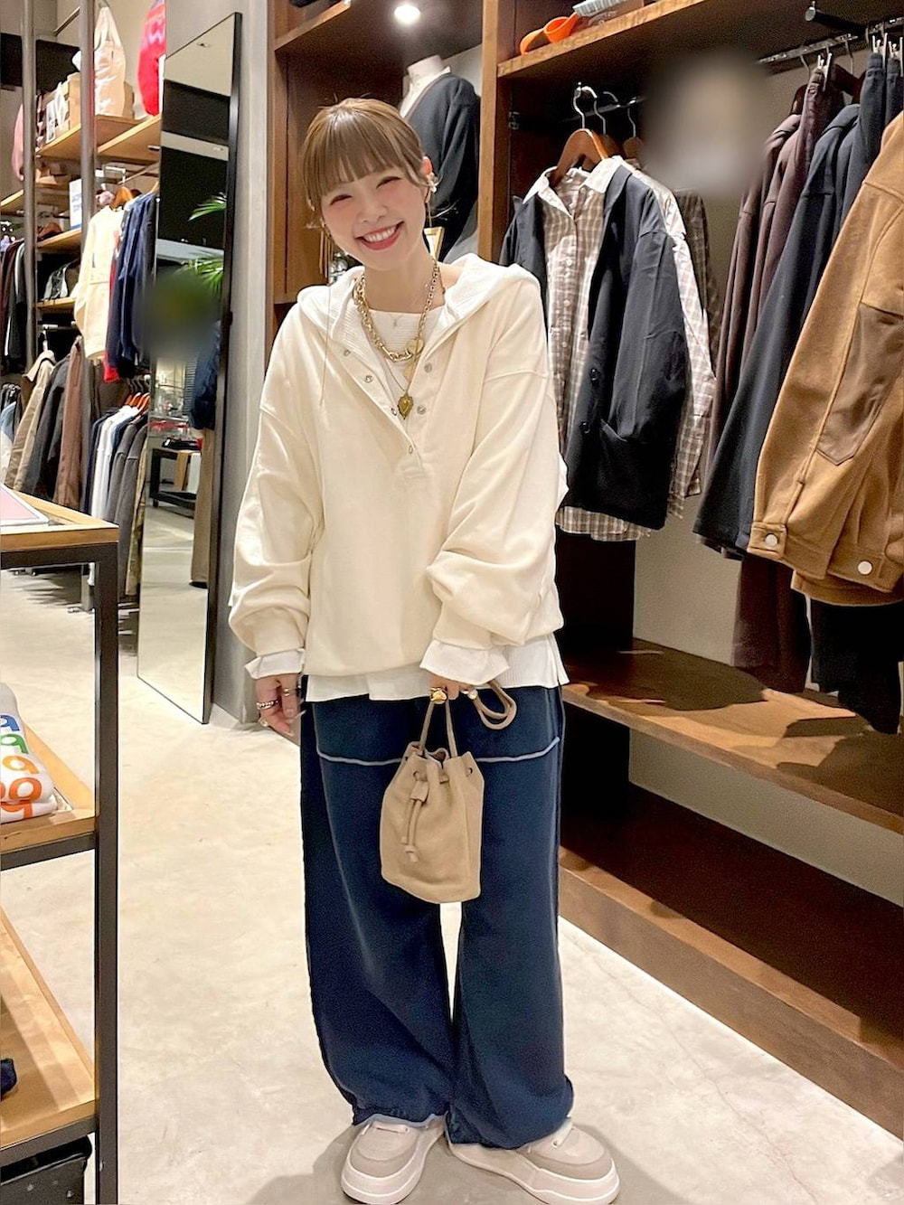 ベージュ系のショルダーバッグ、ホワイト系のパーカー、ホワイト系のTシャツ/カットソーを着用したレディースの冬コーディネートの6枚目の写真