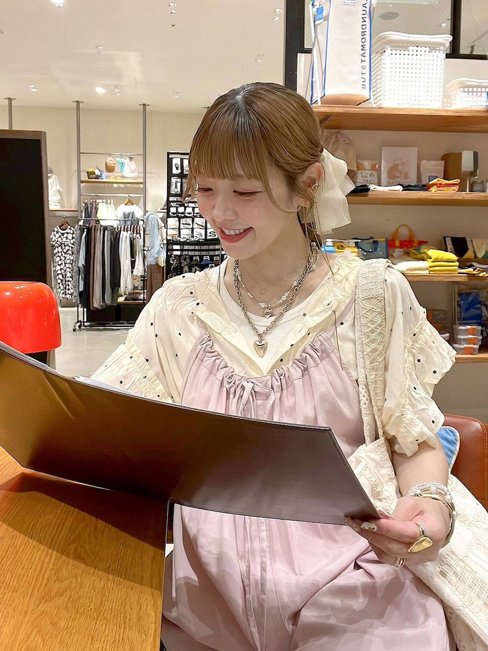 ピンク系のサロペット/オーバーオール、ベージュ系のトートバッグ、ホワイト系のシャツ/ブラウスを着用したレディースの夏コーディネートの3枚目の写真