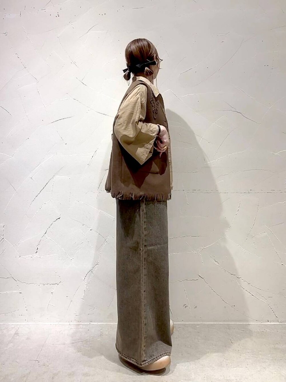 ベージュ系のシャツ/ブラウス、ブラウン系のデニムパンツ、イエロー系のベストを着用したレディースの夏コーディネートの4枚目の写真