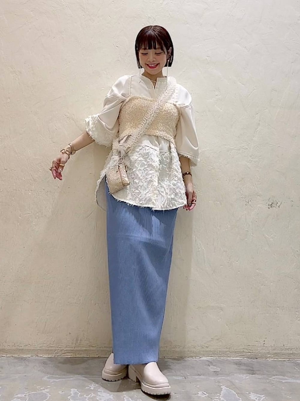 ベージュ系のシャツ/ブラウス、ベージュ系のベスト、ベージュ系のブーツを着用したレディースの冬コーディネートの7枚目の写真