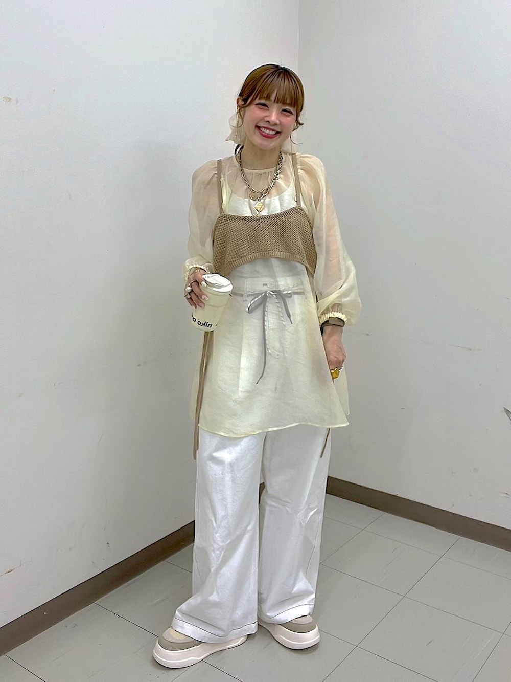 ベージュ系のスニーカー、ゴールド系のリング、グリーン系のアナログ腕時計を着用したレディースの春コーディネートの7枚目の写真