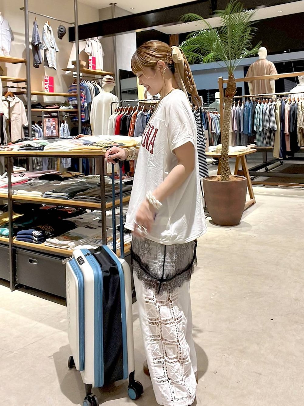 ホワイト系のその他パンツ、ベージュ系のスーツケース/キャリーバッグ、ホワイト系のバックパック/リュックを着用したレディースの夏コーディネートの4枚目の写真