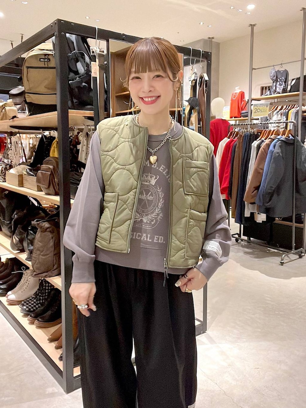 グリーン系のベスト、グレー系のTシャツ/カットソーを着用したレディースの秋コーディネートの6枚目の写真