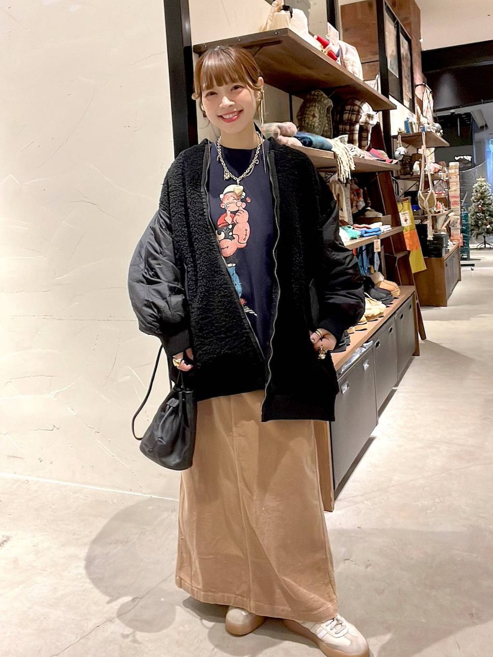 ブラック系のMA-1、イエロー系のスカート、ブルー系のスウェットを着用したレディースの冬コーディネートの4枚目の写真