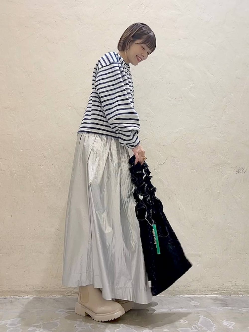 ベージュ系のブーツ、ブラック系のトートバッグ、ホワイト系のTシャツ/カットソーを着用したレディースの冬コーディネートの5枚目の写真