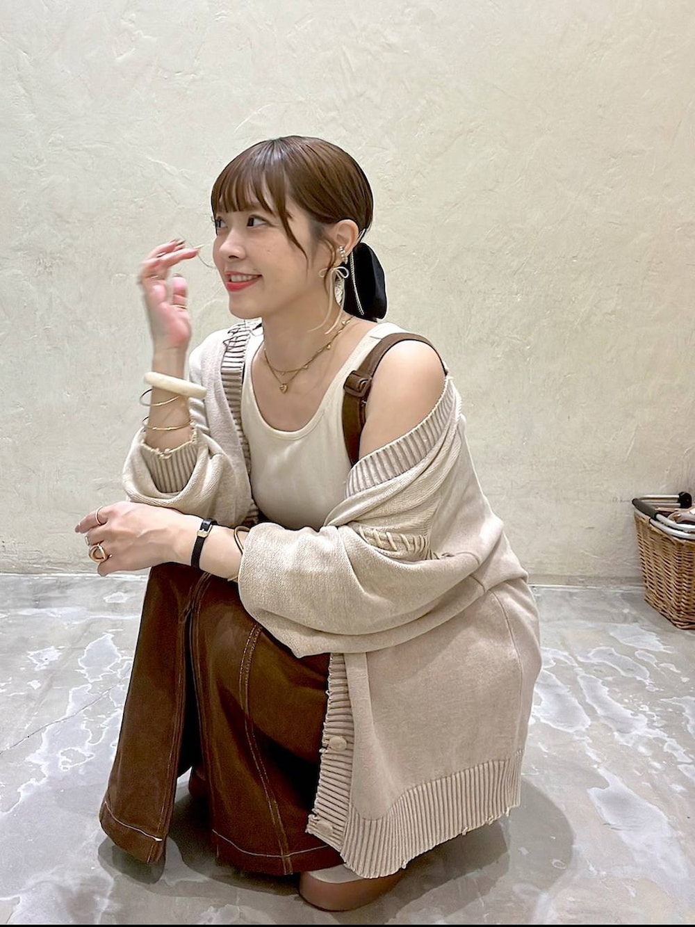 ベージュ系のカーディガン/ボレロ、ブラウン系のスカート、ブラウン系のトートバッグを着用したレディースの秋コーディネートの8枚目の写真