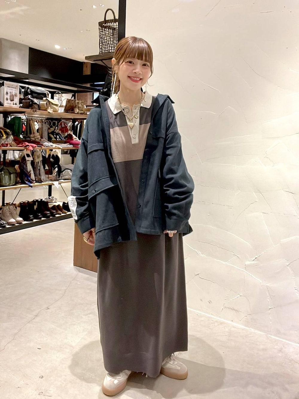 ブラウン系のワンピース、ゴールド系のネックレスを着用したレディースの秋コーディネートの2枚目の写真