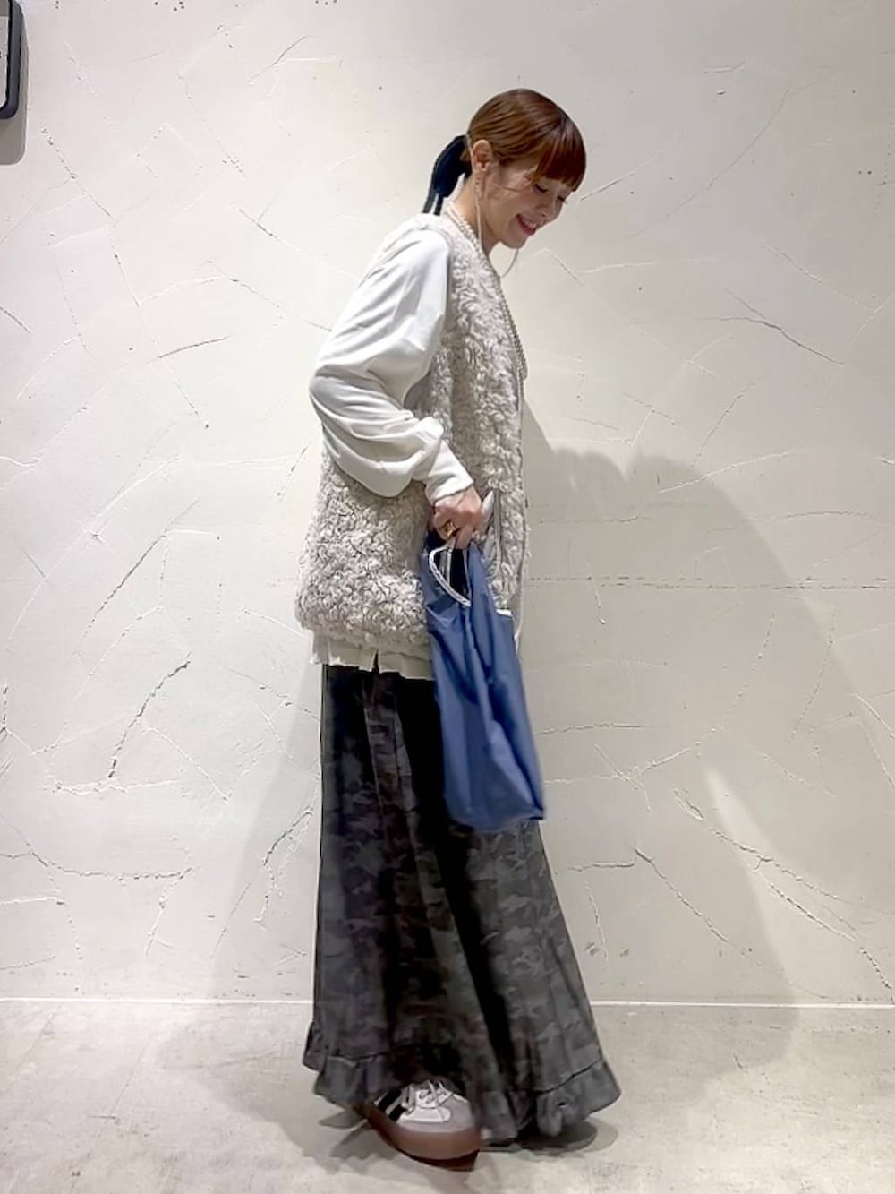 ベージュ系のベスト、その他のトートバッグ、グリーン系のスカートを着用したレディースの秋コーディネートの4枚目の写真