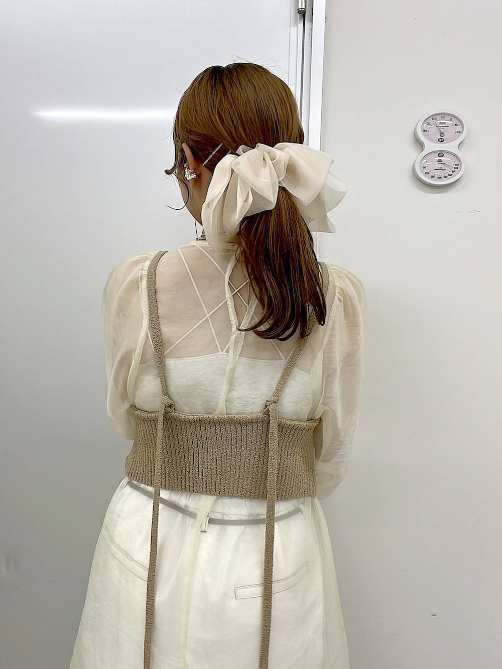 ベージュ系のスニーカー、ゴールド系のリング、グリーン系のアナログ腕時計を着用したレディースの春コーディネートの6枚目の写真