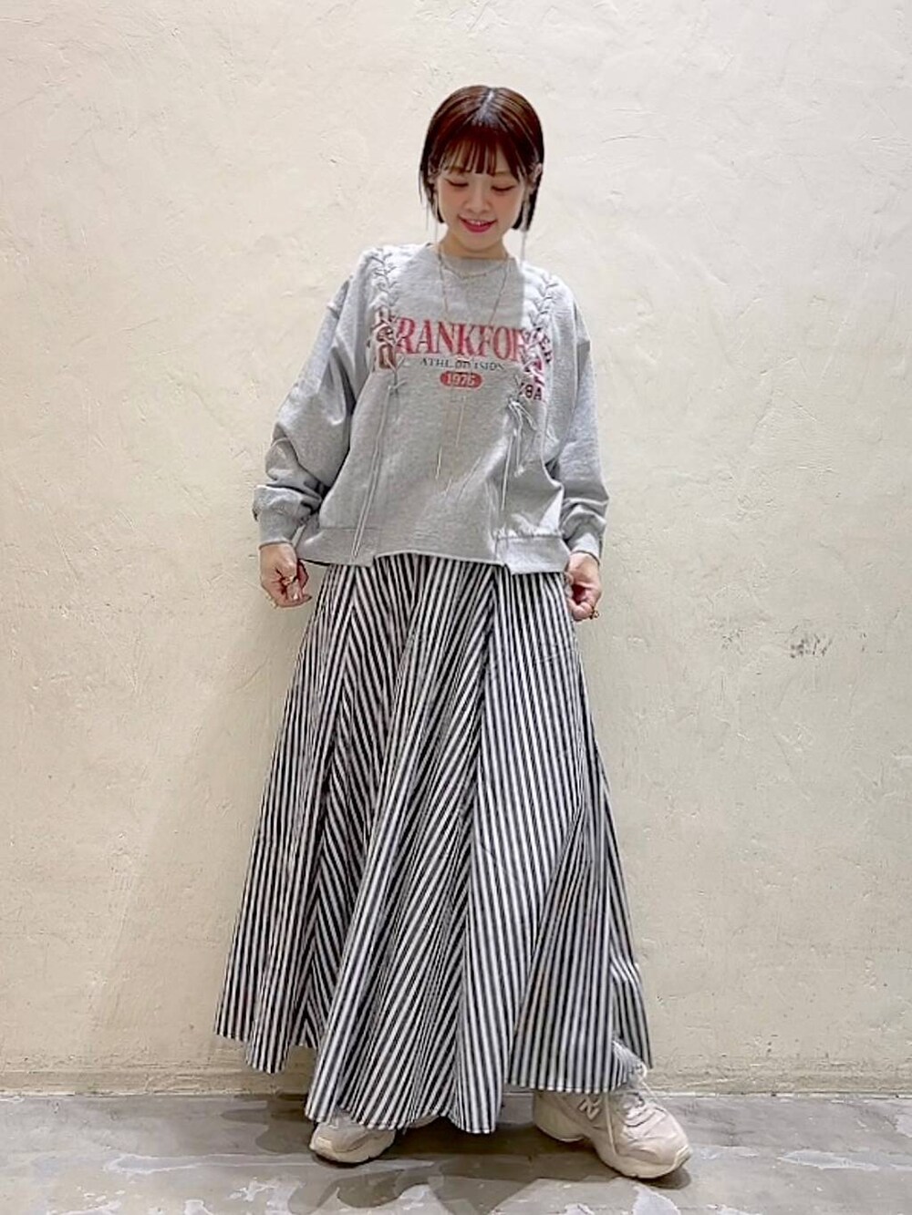 グレー系のTシャツ/カットソー、ブルー系のスカートを着用したレディースの春コーディネートの2枚目の写真