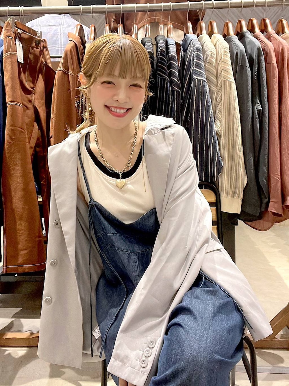 ベージュ系のスニーカー、グレー系のテーラードジャケット、ホワイト系のタンクトップを着用したレディースの春コーディネートの2枚目の写真