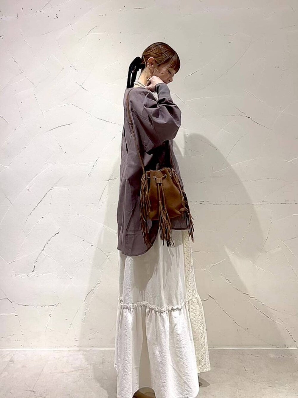 ベージュ系のスカート、ブラウン系のショルダーバッグ、ベージュ系のネックレスを着用したレディースの夏コーディネートの5枚目の写真