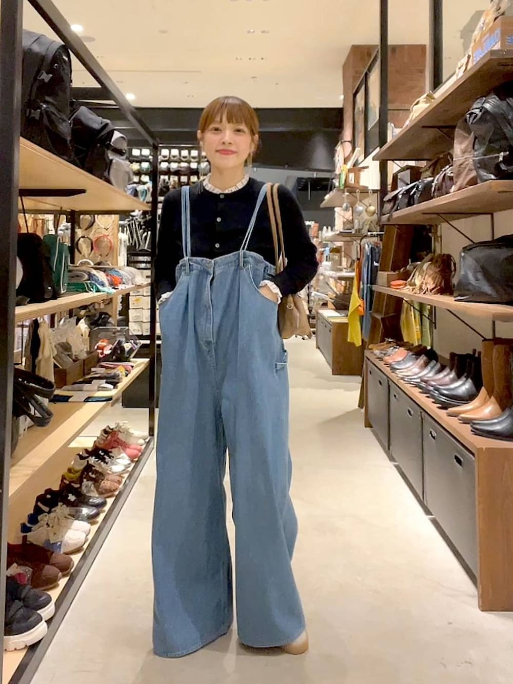 ブラック系のカーディガン/ボレロ、ベージュ系のボストンバッグを着用したレディースの秋コーディネートの2枚目の写真