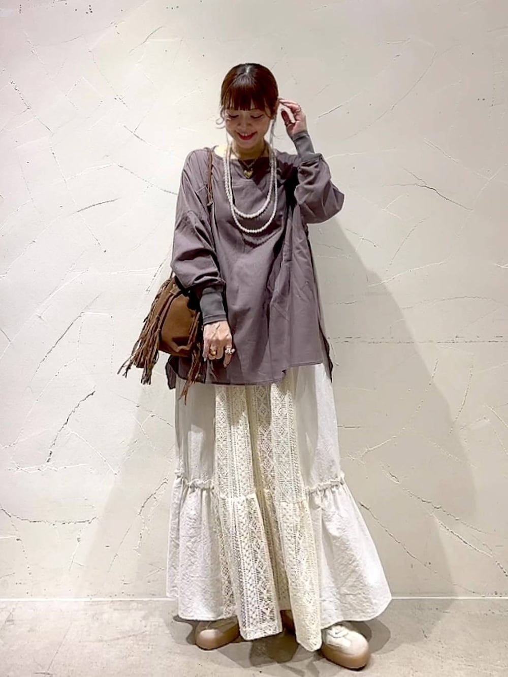 ベージュ系のスカート、ブラウン系のショルダーバッグ、ベージュ系のネックレスを着用したレディースの夏コーディネートの3枚目の写真