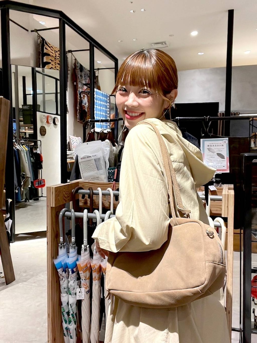 イエロー系のスカート、ベージュ系のボストンバッグ、ベージュ系のワンピースを着用したレディースの秋コーディネートの6枚目の写真