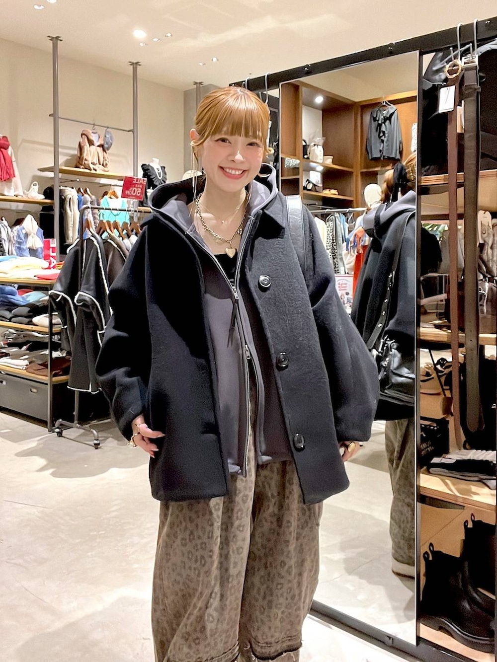 ブラック系のブルゾン、ブラウン系のデニムパンツ、ブラック系のショルダーバッグを着用したレディースの冬コーディネートの6枚目の写真