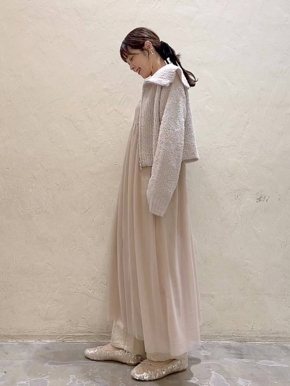 ベージュ系のワンピース、ホワイト系のその他パンツ、ホワイト系のバレエシューズを着用したレディースの冬コーディネートの5枚目の写真