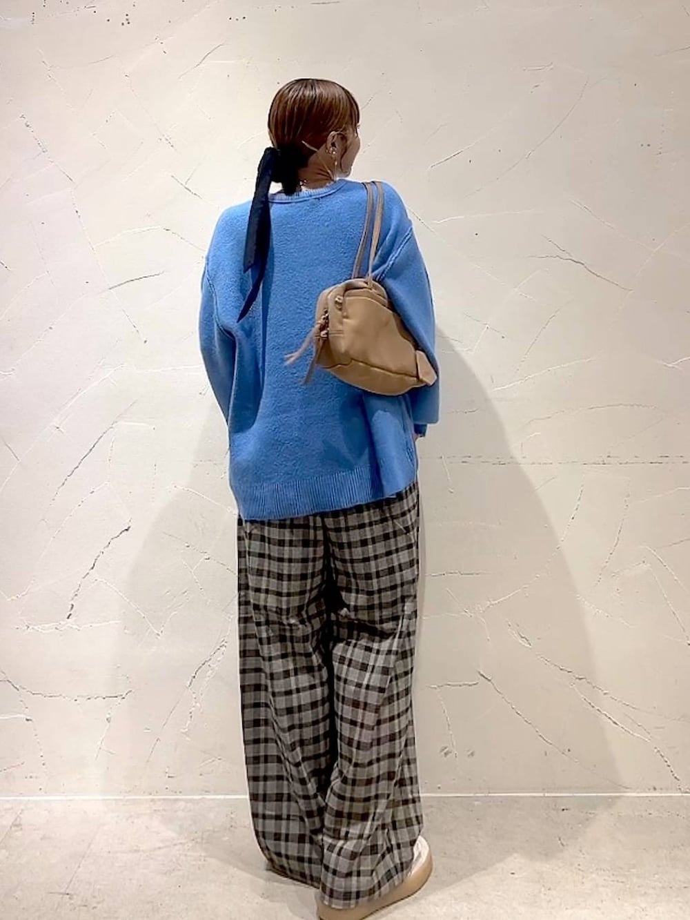ブラウン系のその他パンツ、ブルー系のニット/セーター、ベージュ系のボストンバッグを着用したレディースの秋コーディネートの5枚目の写真