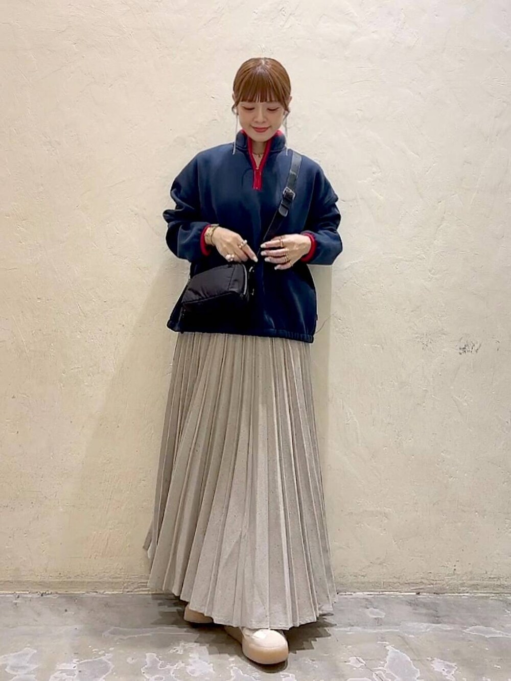 ブルー系のスウェット、ブラック系のショルダーバッグ、グレー系のスカートを着用したレディースの冬コーディネートの2枚目の写真