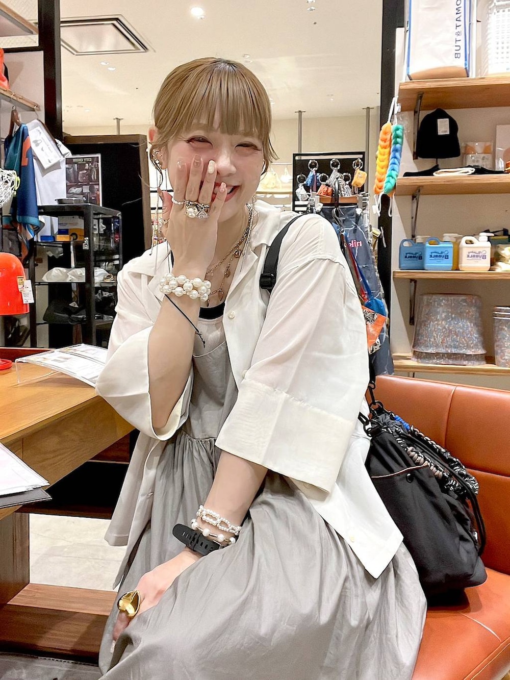 ベージュ系のシャツ/ブラウス、ブラック系のショルダーバッグ、ホワイト系のタンクトップを着用したレディースの夏コーディネートの3枚目の写真