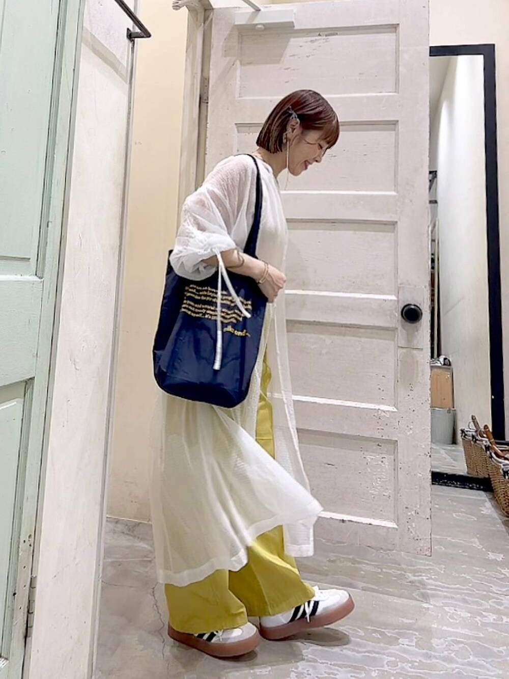 ブルー系のトートバッグ、イエロー系のその他パンツ、ホワイト系のワンピースを着用したレディースの夏コーディネートの3枚目の写真