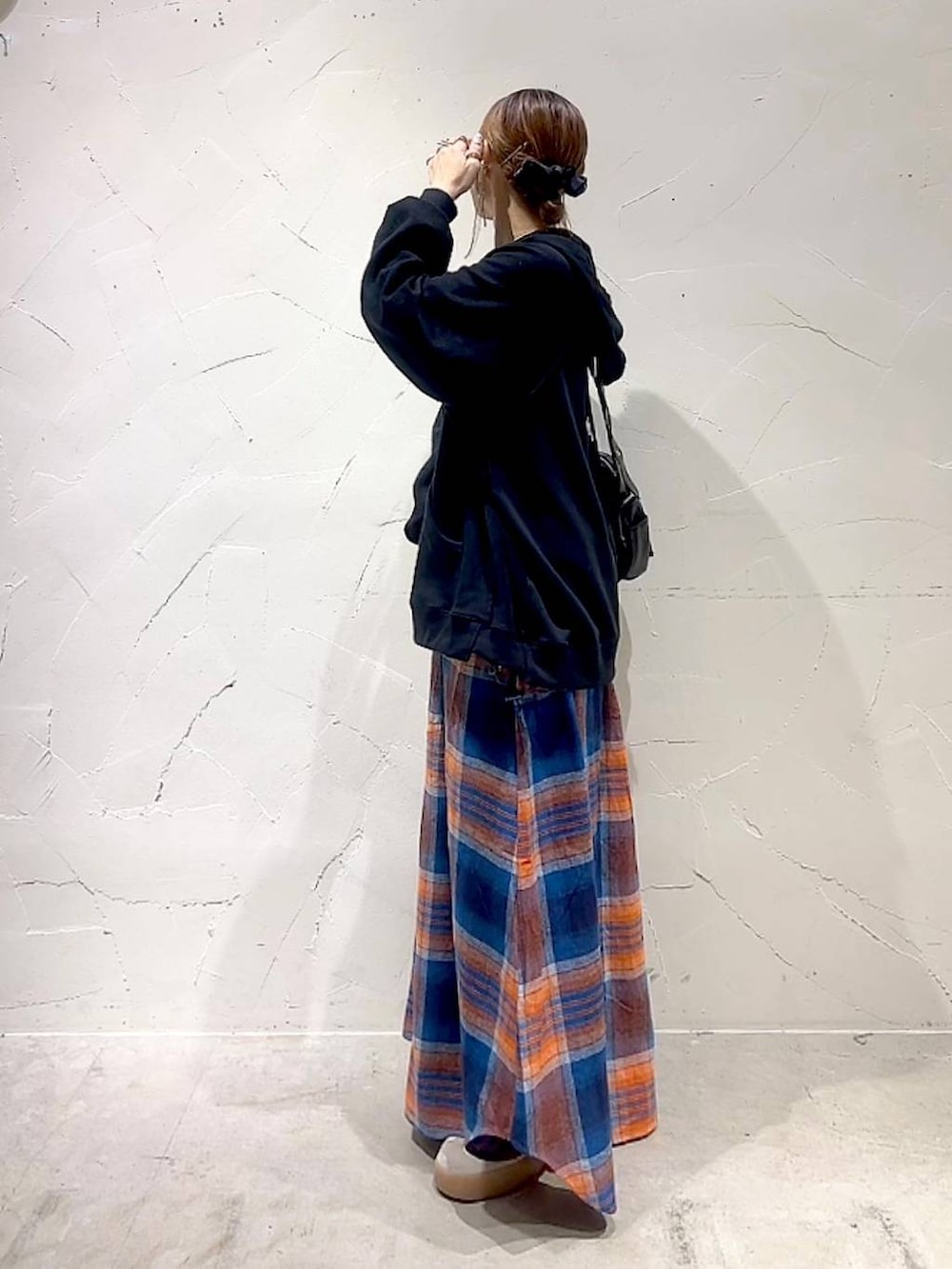 ブラック系のショルダーバッグ、イエロー系のネックレスを着用したレディースの秋コーディネートの6枚目の写真