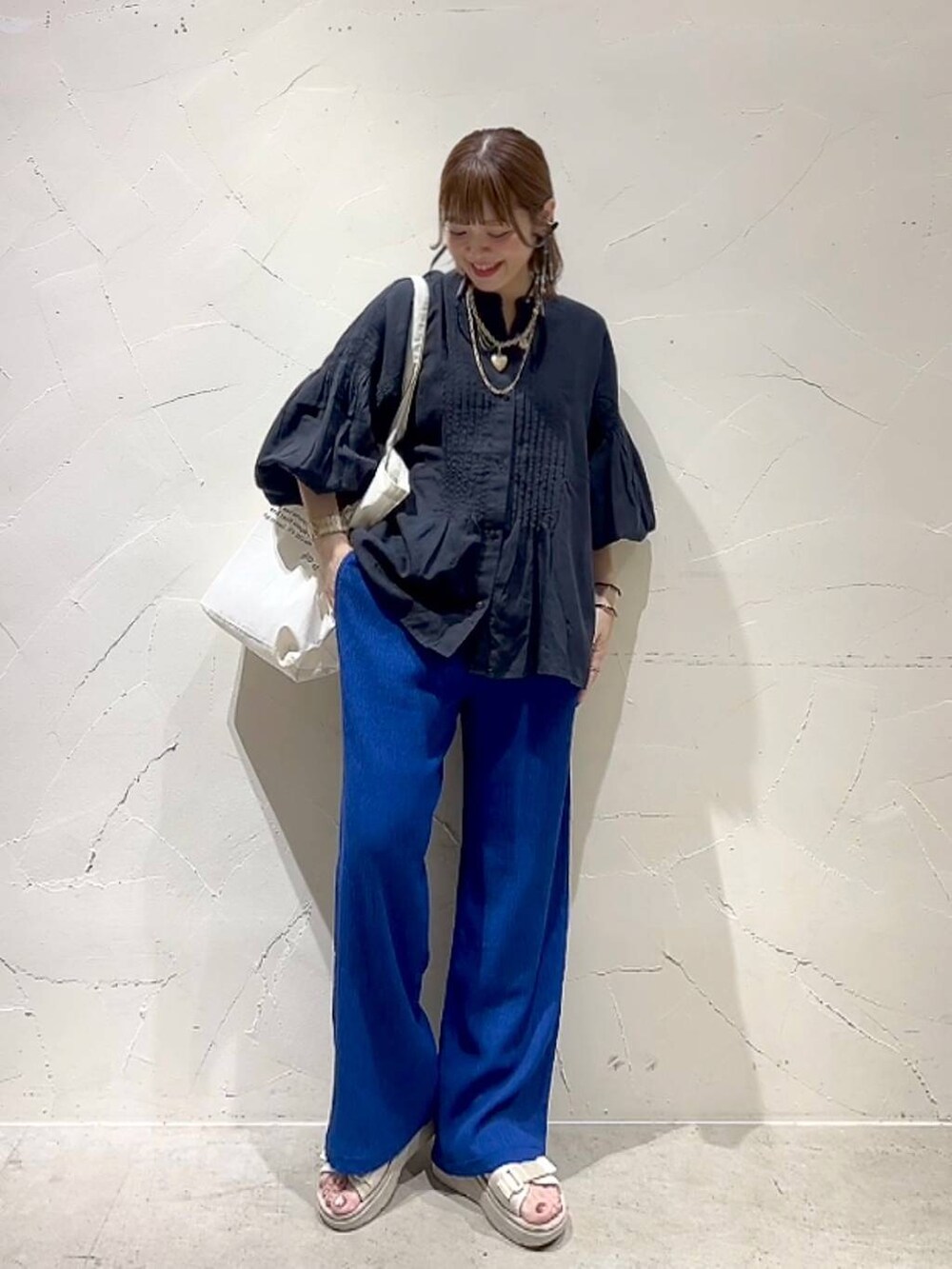 ベージュ系のトートバッグ、ブラック系のシャツ/ブラウス、ブルー系のその他パンツを着用したレディースの春コーディネートの3枚目の写真