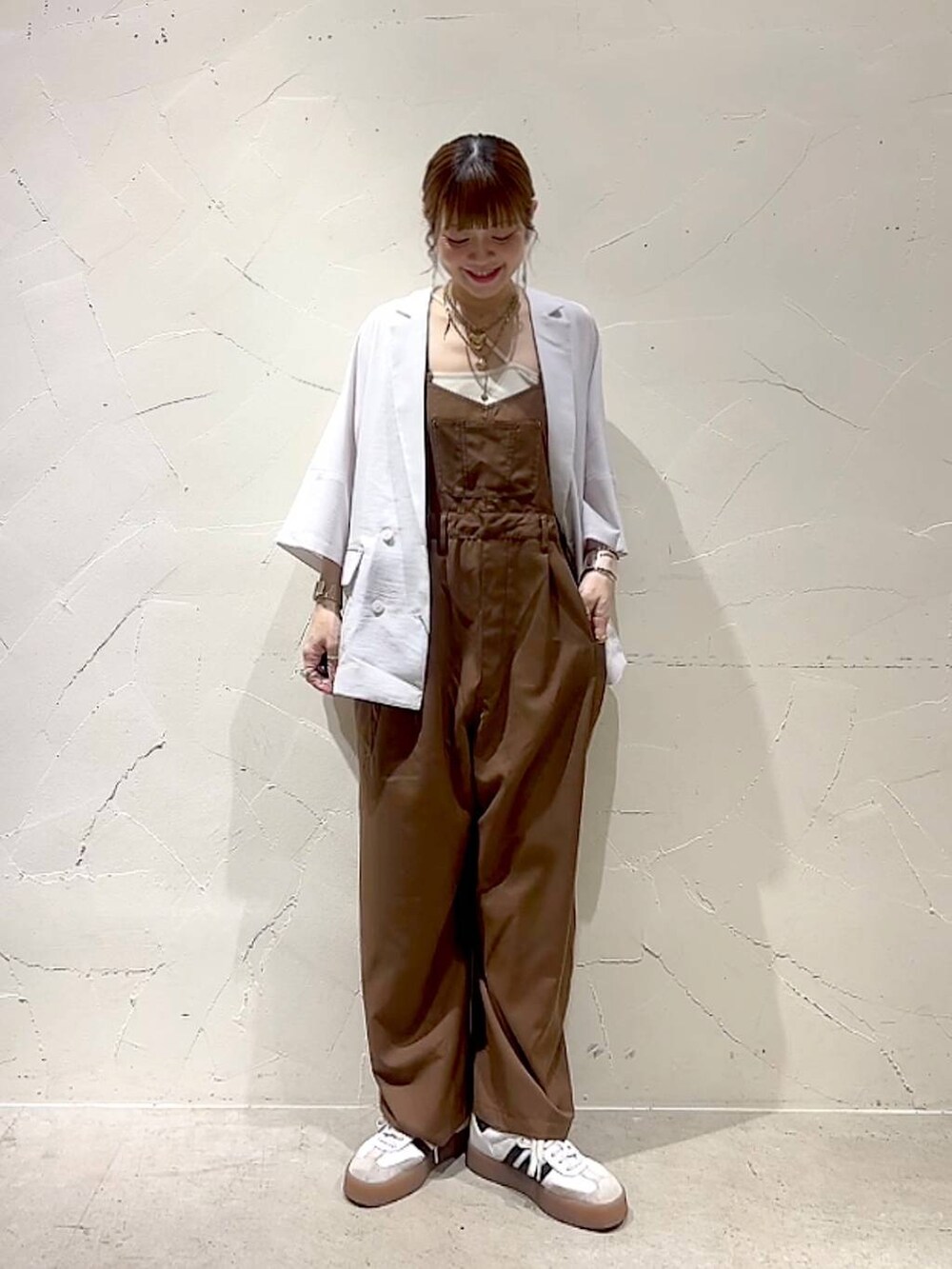 ベージュ系のテーラードジャケット、イエロー系のアナログ腕時計、ベージュ系のネックレスを着用したレディースの春コーディネートの3枚目の写真