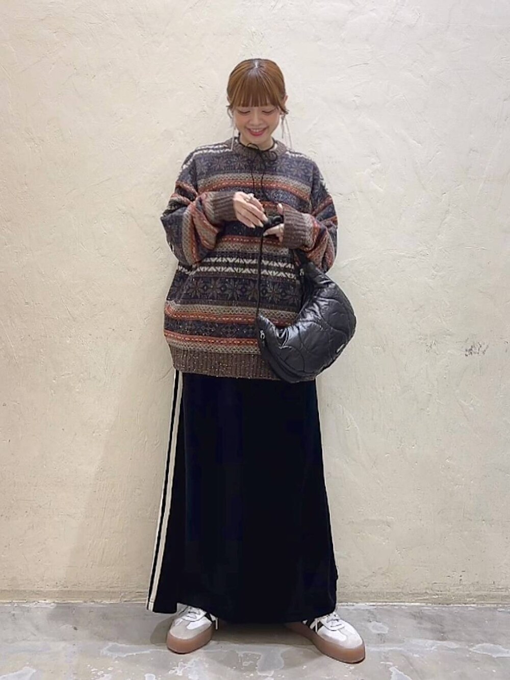 ブラック系のショルダーバッグ、ブラウン系のニット/セーター、ブラック系のスカートを着用したレディースの冬コーディネートの9枚目の写真