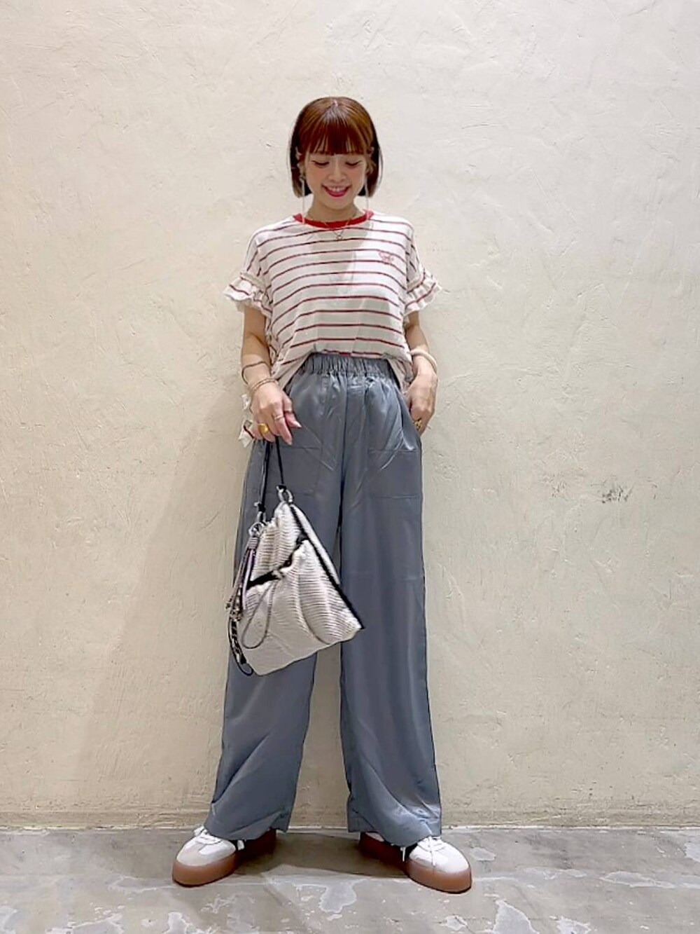 レッド系のTシャツ/カットソー、グレー系のショルダーバッグ、グレー系のその他パンツを着用したレディースの夏コーディネートの6枚目の写真