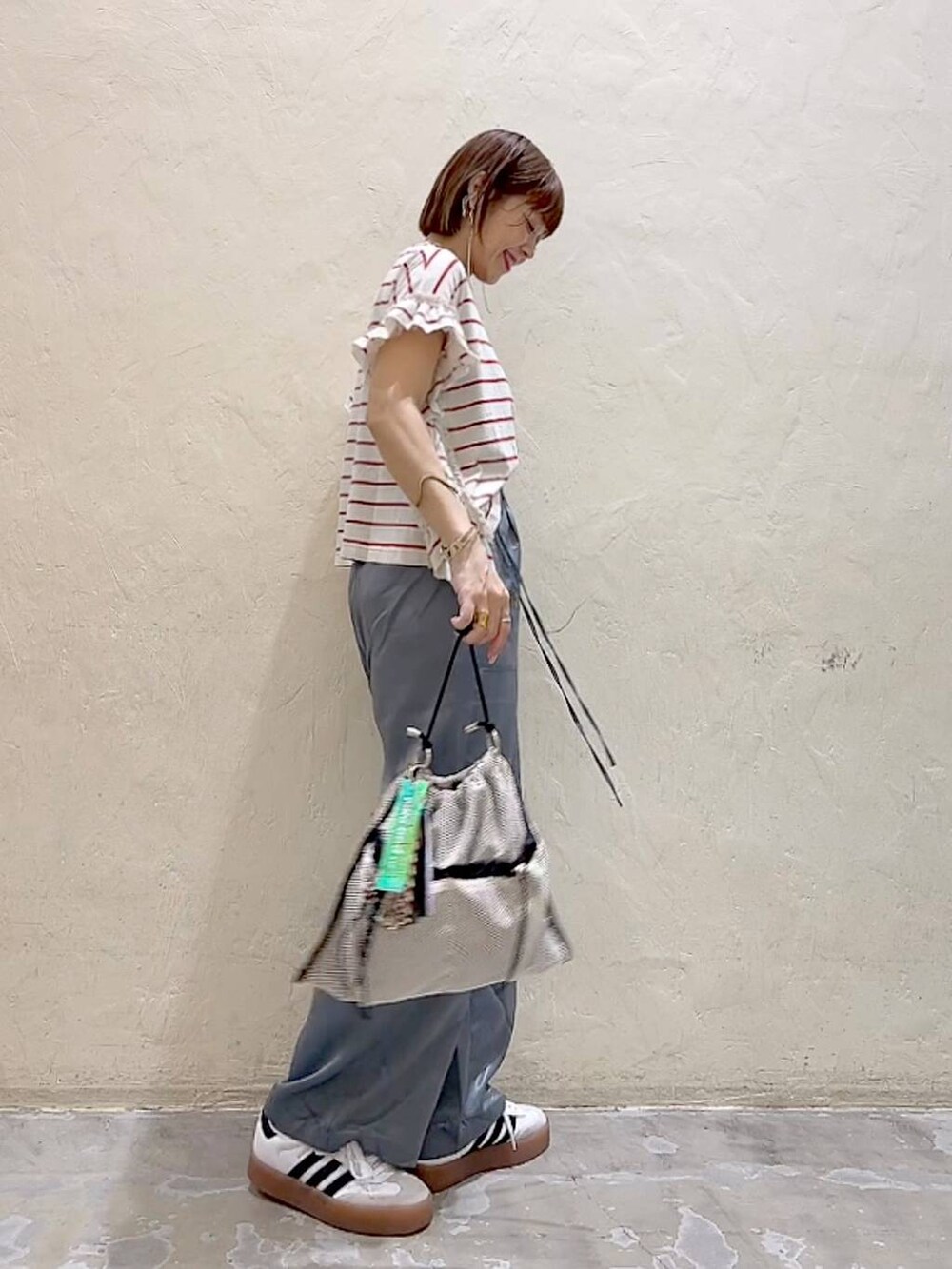 レッド系のTシャツ/カットソー、グレー系のショルダーバッグ、グレー系のその他パンツを着用したレディースの夏コーディネートの3枚目の写真