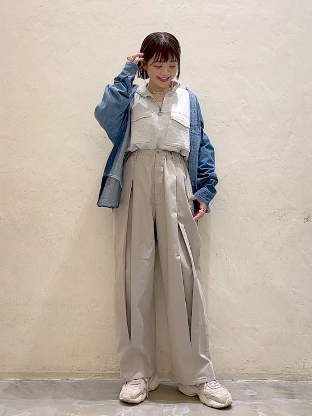 ベージュ系のスウェット、グレー系のチノパンツ、ブルー系のシャツ/ブラウスを着用したレディースの冬コーディネートの2枚目の写真