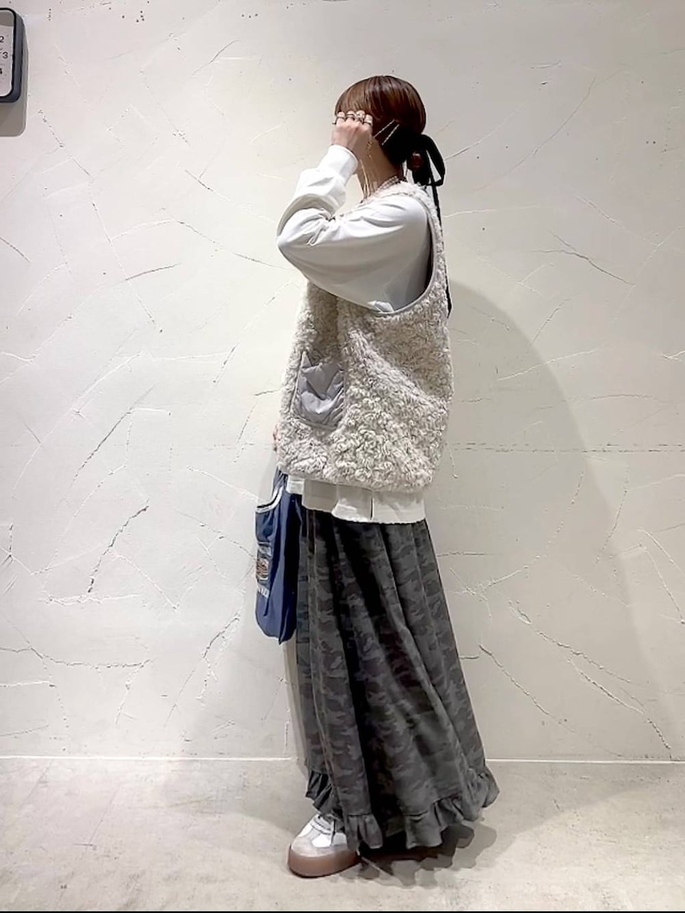 ベージュ系のベスト、その他のトートバッグ、グリーン系のスカートを着用したレディースの秋コーディネートの6枚目の写真