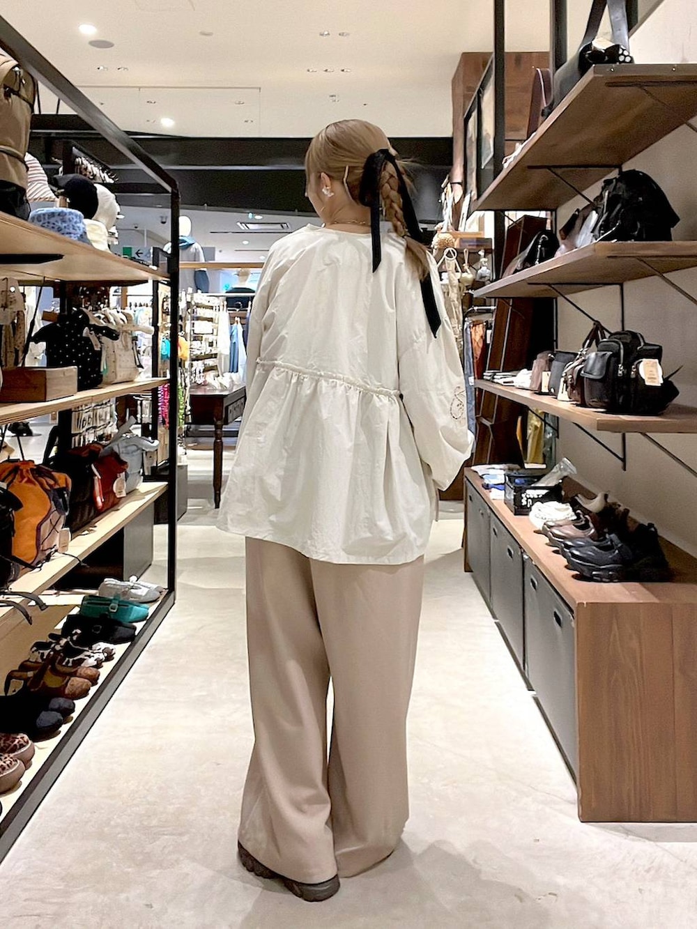 ベージュ系のブルゾン、ブラウン系のスニーカー、ホワイト系のTシャツ/カットソーを着用したレディースの春コーディネートの5枚目の写真