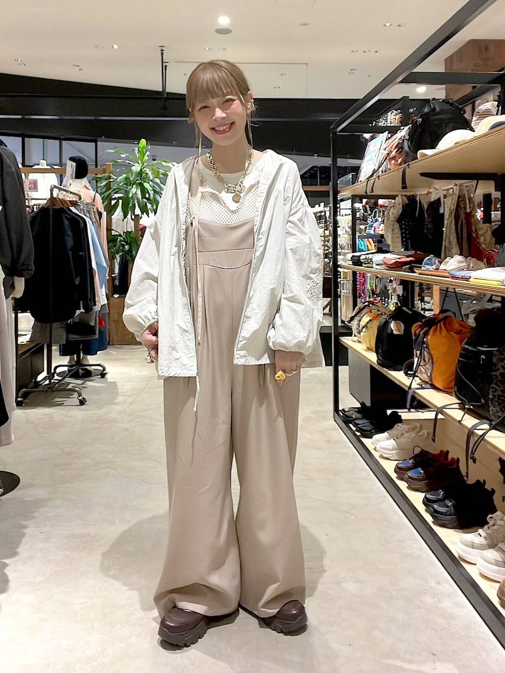 ベージュ系のブルゾン、ブラウン系のスニーカー、ホワイト系のTシャツ/カットソーを着用したレディースの春コーディネートの9枚目の写真